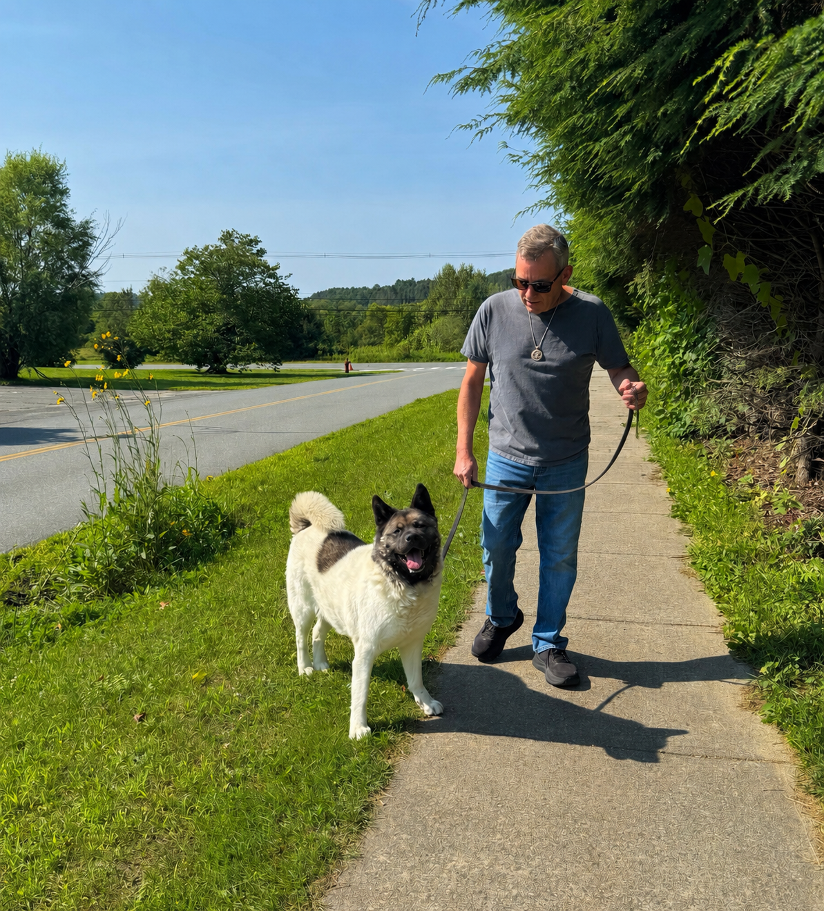 Chris Martel, founder of Heartwork Studios, walking outdoors with his dog in St. Johnsbury, Vermont